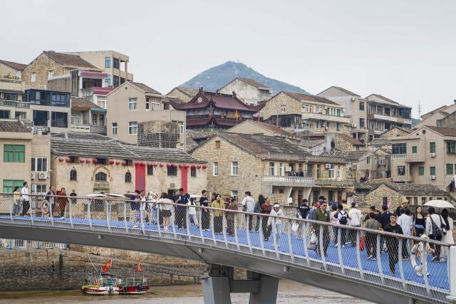 (260726) -- WENLING, July 26, 2026 (Xinhua) -- Tourists visit traditional stone houses in Liruo Village of Shitang Town, Wenling City, east China's Zhejiang Province, May 2, 2026. Liruo is a village located in the southwestern part of Shitang Town, Wenling City. For generations, local residents have relied on the sea for their livelihood. The village is known for its distinctive stone constructions, which were built to withstand typhoons and other severe weather.
   Today, the ancient fishing village is boosting its cultural and tourism industries. Many traditional stone houses have been transformed into cafes and homestays, while fishing nets are crafted into handbags, serving as souvenirs for tourists together with other cultural and creative products. (Xinhua/Jiang Han)
