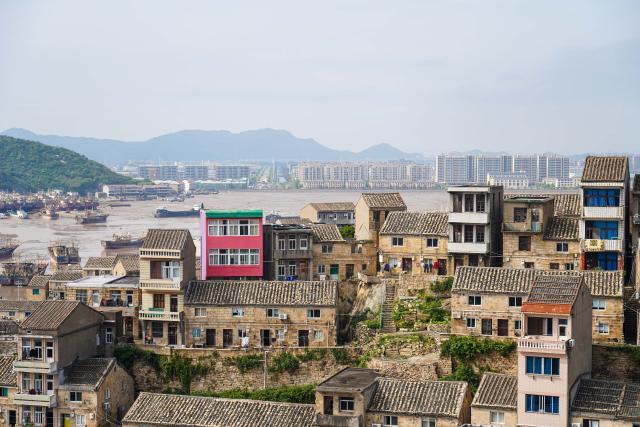 (260726) -- WENLING, July 26, 2026 (Xinhua) -- This photo taken on May 2, 2026 shows stone houses in Liruo Village of Shitang Town, Wenling City, east China's Zhejiang Province. Liruo is a village located in the southwestern part of Shitang Town, Wenling City. For generations, local residents have relied on the sea for their livelihood. The village is known for its distinctive stone constructions, which were built to withstand typhoons and other severe weather.
   Today, the ancient fishing village is boosting its cultural and tourism industries. Many traditional stone houses have been transformed into cafes and homestays, while fishing nets are crafted into handbags, serving as souvenirs for tourists together with other cultural and creative products. (Xinhua/Jiang Han)