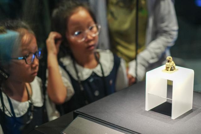(260726) -- BEIJING, July 26, 2026 (Xinhua) -- Children look at an exhibit at Jiangkou sunken silver museum in Meishan City, southwest China's Sichuan Province, July 25, 2026. Museums have become popular in hot summer in many regions across China, drawing large crowds seeking both knowledge and coolness. (Photo by Weng Guangjian/Xinhua)