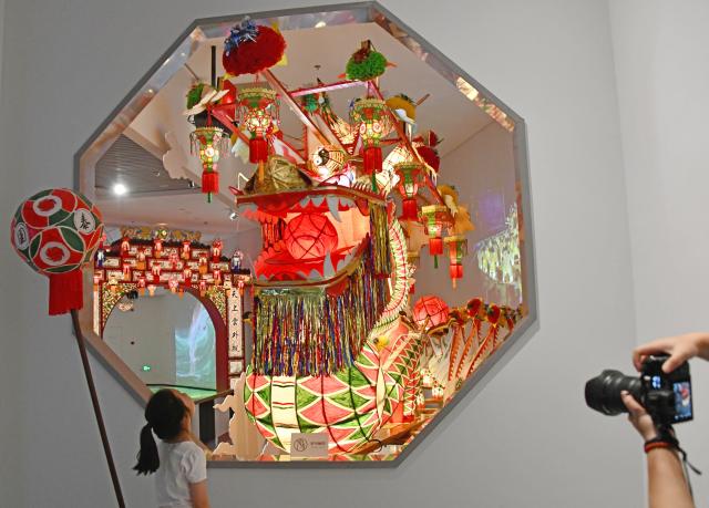(260726) -- BEIJING, July 26, 2026 (Xinhua) -- A girl looks at a dragon exhibit at a museum in Xianju County of Taizhou, east China's Zhejiang Province, July 24, 2026. Museums have become popular in hot summer in many regions across China, drawing large crowds seeking both knowledge and coolness. (Photo by Wang Huabin/Xinhua)