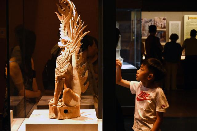 (260726) -- BEIJING, July 26, 2026 (Xinhua) -- A boy looks at an exhibit at Dunhuang Museum in Dunhuang, northwest China's Gansu Province, July 25, 2026. Museums have become popular in hot summer in many regions across China, drawing large crowds seeking both knowledge and coolness. (Photo by Zhang Xiaoliang/Xinhua)