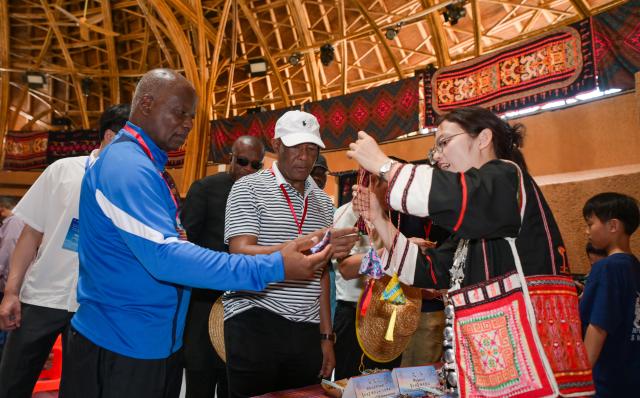 (260726) -- HAIKOU, July 26, 2026 (Xinhua) -- Diplomatic envoys learn about local culture in Maona Village of Shuiman Township, Wuzhishan City, south China's Hainan Province, July 23, 2026. At the invitation of the Chinese Ministry of Foreign Affairs, more than 30 ambassadors and senior diplomats visited Sanya, Wuzhishan, Qionghai, Wenchang and Haikou in south China's Hainan Province from Wednesday to Saturday. During the visit, they explored Hainan's scientific and technological innovation, and the development of the Hainan Free Trade Port. (Xinhua/Yang Guanyu)