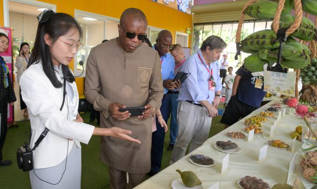 (260726) -- HAIKOU, July 26, 2026 (Xinhua) -- Diplomatic envoys learn about tropical fruits in Qionghai City, south China's Hainan Province, July 24, 2026. At the invitation of the Chinese Ministry of Foreign Affairs, more than 30 ambassadors and senior diplomats visited Sanya, Wuzhishan, Qionghai, Wenchang and Haikou in south China's Hainan Province from Wednesday to Saturday. During the visit, they explored Hainan's scientific and technological innovation, and the development of the Hainan Free Trade Port. (Xinhua/Yang Guanyu)