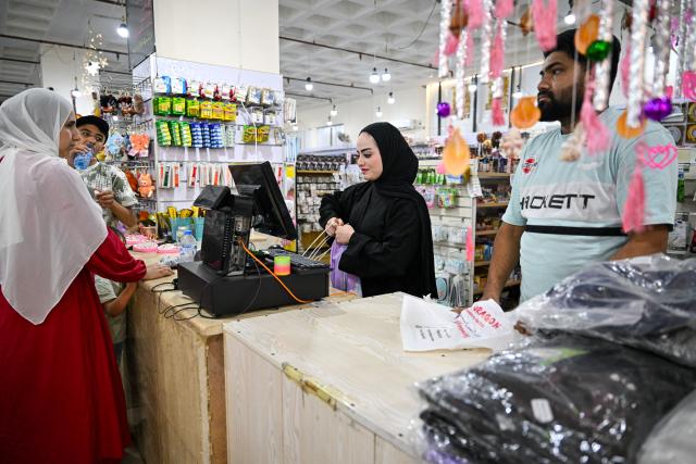 (260727) -- AMMAN, July 27, 2026 (Xinhua) -- A cashier rings up groceries at a Chinese shopping mall in Aqaba, Jordan, July 24, 2026. As the economic and trade cooperation and cultural exchanges between China and Jordan continue to deepen, a growing number of Chinese elements have found their way into the daily lives of Jordanians. (Xinhua/Xin Mengchen)