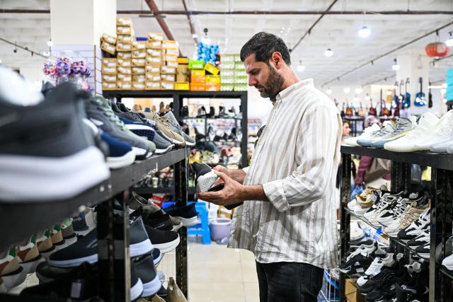 (260727) -- AMMAN, July 27, 2026 (Xinhua) -- A customer selects goods at a Chinese shopping mall in Aqaba, Jordan, July 24, 2026. As the economic and trade cooperation and cultural exchanges between China and Jordan continue to deepen, a growing number of Chinese elements have found their way into the daily lives of Jordanians. (Xinhua/Xin Mengchen)