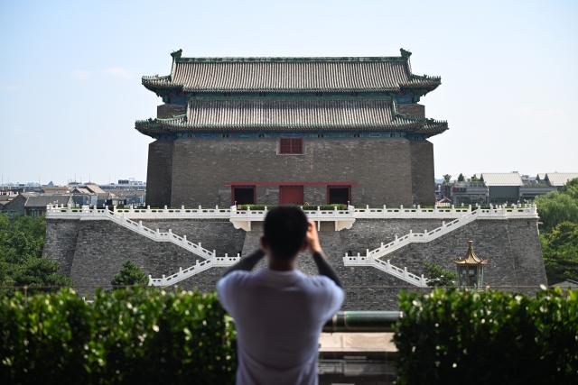 (260727) -- BEIJING, July 27, 2026 (Xinhua) -- A visitor takes photos of the Zhengyangmen Archery Tower on the Zhengyangmen Gate in Beijing, capital of China, July 27, 2026. Marking the second anniversary of the successful inscription of the Beijing Central Axis on the UNESCO World Heritage List, heritage sites along the central axis, such as the Palace Museum, Zhengyangmen Gate, and Altar of the God of Agriculture, also referred to as the Xiannongtan Temple, were opened to the public, and some sites launched new exhibitions on Monday.
   Stretching 7.8 kilometers from Yongding Gate in the south to the Drum and Bell Towers in the north, the Beijing Central Axis was constructed based on ancient architectural philosophies to create an ideal layout for a capital city. The Central Axis can be traced back to the early Yuan Dynasty (1271-1368), and its length was extended in the Ming and Qing dynasties. (Xinhua/Chen Zhonghao)