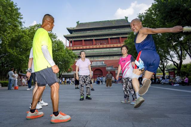 (260727) -- BEIJING, July 27, 2026 (Xinhua) -- People kick a shuttlecock at a square connecting the Drum and Bell Towers in Beijing, capital of China, July 27, 2026. The second anniversary of the inscription of the Beijing Central Axis on the UNESCO World Heritage List falls on July 27.
   Since its inscription, the 7.8-kilometer-long axis has continued to gain new vitality, attracting more visitors to experience Beijing's historical heritage amid the blend of ancient architecture and modern life, while bringing World Heritage closer to everyday life.
   Stretching from the Bell and Drum Towers in the north to Yongdingmen Gate in the south, the Beijing Central Axis reflects traditional Chinese urban planning and serves as the spatial backbone of the old city. Carrying the history of Beijing's urban development, it bears witness to the continuity of Chinese civilization and reflects the capital's evolution through the ages. (Xinhua/Zhang Xiaoyu)