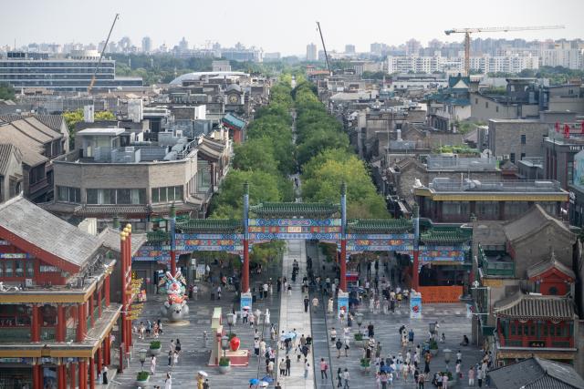 (260727) -- BEIJING, July 27, 2026 (Xinhua) -- This photo taken from the Zhengyangmen Archery Tower shows a view of the Qianmen pedestrian street in Beijing, capital of China, July 27, 2026. The second anniversary of the inscription of the Beijing Central Axis on the UNESCO World Heritage List falls on July 27.
   Since its inscription, the 7.8-kilometer-long axis has continued to gain new vitality, attracting more visitors to experience Beijing's historical heritage amid the blend of ancient architecture and modern life, while bringing World Heritage closer to everyday life.
   Stretching from the Bell and Drum Towers in the north to Yongdingmen Gate in the south, the Beijing Central Axis reflects traditional Chinese urban planning and serves as the spatial backbone of the old city. Carrying the history of Beijing's urban development, it bears witness to the continuity of Chinese civilization and reflects the capital's evolution through the ages. (Xinhua/Hu Jingwen)