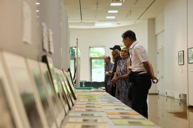 (260727) -- KANAGAWA, July 27, 2026 (Xinhua) -- People visit an exhibition on the construction of the Sagami Reservoir at the exchange center of the reservoir in Kanagawa Prefecture, Japan, July 26, 2026. More than 200 people, including officials from China, South Korea and Japan, as well as local residents, attended the annual event at the Sagamiko Exchange Center honoring those who lost their lives while working on the reservoir project.
  TO GO WITH "Japan holds memorial for multinational laborers who died in reservoir construction" (Xinhua/Yue Chenxing)