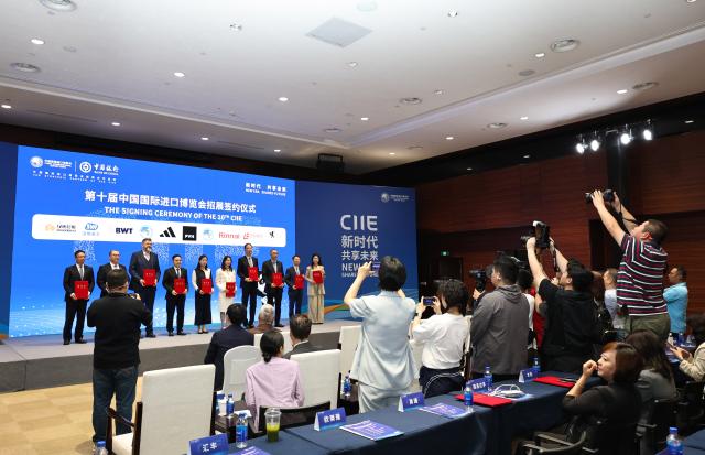 (260727) -- SHANGHAI, July 27, 2026 (Xinhua) -- People pose for a photo during the signing ceremony of the 10th China International Import Expo (CIIE) at the National Exhibition and Convention Center (Shanghai), the main venue for the ninth CIIE, in east China's Shanghai, on July 27, 2026. A series of events, including a news briefing, a promotion and roadshow, and a signing ceremony of the 10th CIIE, was held at the center on Monday, marking the 100-day countdown to the 9th CIIE.
   The 9th CIIE is scheduled to be held in Shanghai from Nov. 5 to 10. (Xinhua/Fang Zhe)