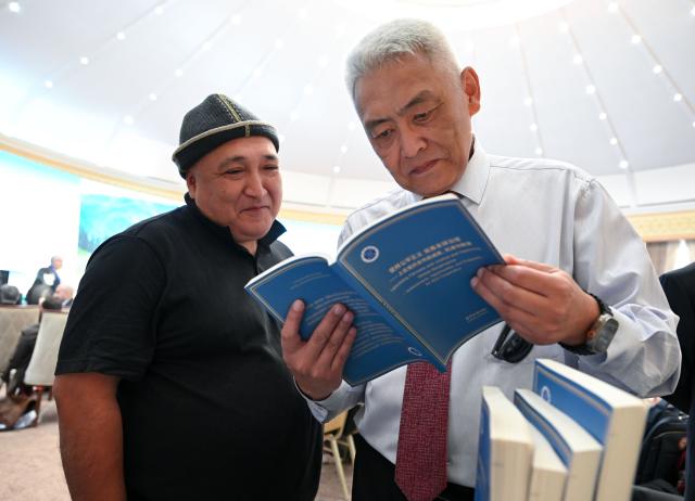 (260727) -- BISHKEK, July 27, 2026 (Xinhua) -- Participants read a copy of the Xinhua think tank report titled "Upholding Fairness and Justice and Improving Global Governance -- Achievements, Opportunities, and Prospects for SCO Cooperation" at the 2026 Shanghai Cooperation Organization (SCO) Media and Think Tank Summit in Bishkek, Kyrgyzstan, July 27, 2026.
  The report, which was released here on Monday by the National High-Level Think Tank of Xinhua News Agency, offered a systematic review of the SCO's pioneering achievements and historic accomplishments over the past 25 years since its founding, an in-depth analysis of the broad opportunities for cooperation within the organization in the current international situation, and a comprehensive presentation of the broad prospects and global significance of building an SCO community with a shared future. (Xinhua/Feng Kaihua)