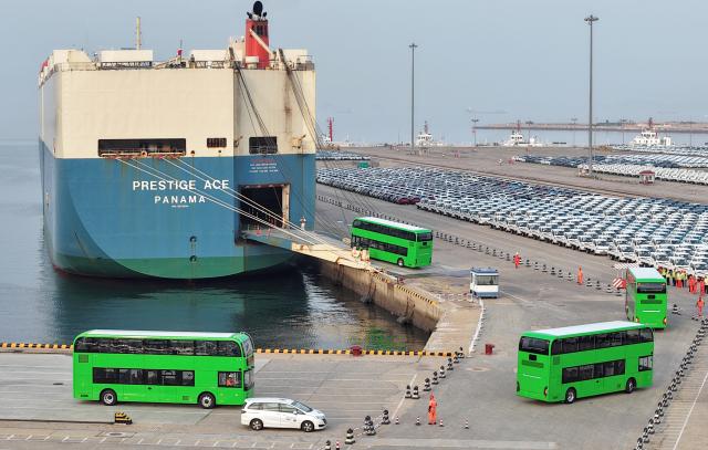 (260728) -- YANTAI, July 28, 2026 (Xinhua) -- A drone photo taken on July 27, 2026 shows homemade electric double-decker buses heading to a car carrier at Yantai Port in Yantai, east China's Shandong Province. A total of 35 Chinese bus maker Yutong's U11DD electric double-decker buses on Monday were shipped from the Yantai Port to Britain. The type of bus, designed specifically for the European markets, has been put into service in London's public transport system. (Photo by Tang Ke/Xinhua)