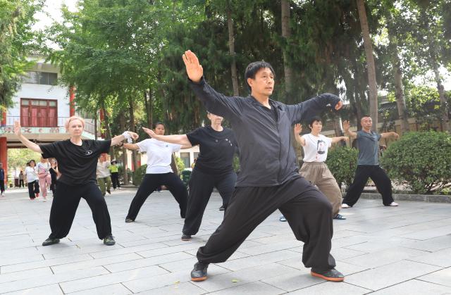(260728) -- ZHENGZHOU, July 28, 2026 (Xinhua) -- Tai Chi coach Chen Ziqiang (front) guides students in practicing Tai Chi in Chenjiagou in Wenxian County, central China's Henan Province, July 27, 2026. This summer, numerous foreign enthusiasts of Tai Chi visited Chenjiagou, a small village in Henan Province where Tai Chi originated, to practice Tai Chi and experience Chinese martial arts culture.
  Rooted in Chinese philosophy, traditional medicine and martial arts, Tai Chi has evolved into a wide range of styles and is now practiced in more than 180 countries and regions, with hundreds of millions of practitioners worldwide. (Photo by Huang Fuxing/Xinhua)