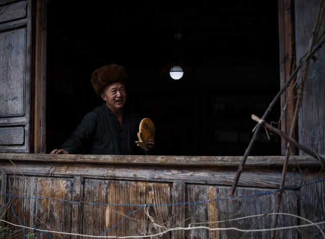(260728) -- KUNMING, July 28, 2026 (Xinhua) -- This photo taken on July 26, 2026 shows a local resident introducing tea products to visitors in Lushi ancient town in Fengqing County of Lincang City in southwest China's Yunnan Province. Lushi ancient town in the northeast of Fengqing County lies between the Lancang River and Heihui River. Due to its special geographical location, Lushi was once an important trading hub on the ancient Tea Horse Road, a trade route dating back to the Tang Dynasty (618-907). The town has formed an unique culture that is influenced by merchants coming and going as well as multi-ethnic cohabitation. (Photo by Lan Hongguang/Xinhua)