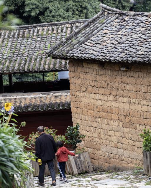 (260728) -- KUNMING, July 28, 2026 (Xinhua) -- This photo taken on July 26, 2026 shows local residents walking in Lushi ancient town in Fengqing County of Lincang City in southwest China's Yunnan Province. Lushi ancient town in the northeast of Fengqing County lies between the Lancang River and Heihui River. Due to its special geographical location, Lushi was once an important trading hub on the ancient Tea Horse Road, a trade route dating back to the Tang Dynasty (618-907). The town has formed an unique culture that is influenced by merchants coming and going as well as multi-ethnic cohabitation. (Photo by Lan Hongguang/Xinhua)