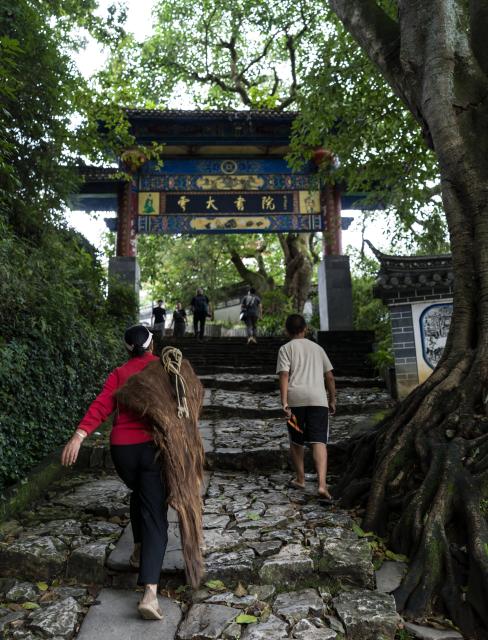 (260728) -- KUNMING, July 28, 2026 (Xinhua) -- This photo taken on July 26, 2026 shows local residents walking in Lushi ancient town in Fengqing County of Lincang City in southwest China's Yunnan Province. Lushi ancient town in the northeast of Fengqing County lies between the Lancang River and Heihui River. Due to its special geographical location, Lushi was once an important trading hub on the ancient Tea Horse Road, a trade route dating back to the Tang Dynasty (618-907). The town has formed an unique culture that is influenced by merchants coming and going as well as multi-ethnic cohabitation. (Photo by Lan Hongguang/Xinhua)