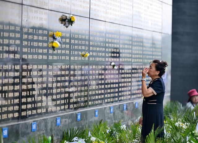 (260728) -- TANGSHAN, July 28, 2026 (Xinhua) -- A citizen mourns in front of a memorial wall inscribed with names of the victims at the Tangshan Earthquake Memorial Park in Tangshan, north China's Hebei Province, July 28, 2026. This year marks the 50th anniversary of the Tangshan Earthquake, a magnitude-7.8 quake that struck the city on July 28, 1976, taking the lives of more than 240,000 people and destroying virtually all buildings in the city.
   Crowds of people visited the Tangshan Earthquake Memorial Park on Tuesday to mourn and remember the victims in the devastating disaster. (Xinhua/Mu Yu)