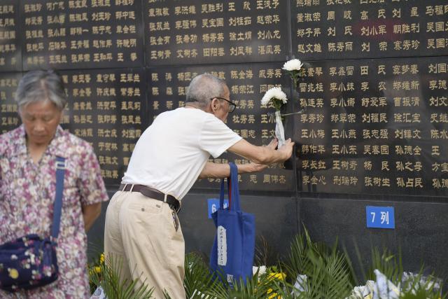 (260728) -- TANGSHAN, July 28, 2026 (Xinhua) -- A citizen places flowers near the name of his relative on a memorial wall inscribed with names of the victims at the Tangshan Earthquake Memorial Park in Tangshan, north China's Hebei Province, July 28, 2026. This year marks the 50th anniversary of the Tangshan Earthquake, a magnitude-7.8 quake that struck the city on July 28, 1976, taking the lives of more than 240,000 people and destroying virtually all buildings in the city.
   Crowds of people visited the Tangshan Earthquake Memorial Park on Tuesday to mourn and remember the victims in the devastating disaster. (Photo by Zhao Liang/Xinhua)