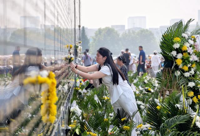 (260728) -- TANGSHAN, July 28, 2026 (Xinhua) -- A citizen places flowers near the name of her relative on a memorial wall inscribed with names of the victims at the Tangshan Earthquake Memorial Park in Tangshan, north China's Hebei Province, July 28, 2026. This year marks the 50th anniversary of the Tangshan Earthquake, a magnitude-7.8 quake that struck the city on July 28, 1976, taking the lives of more than 240,000 people and destroying virtually all buildings in the city.
   Crowds of people visited the Tangshan Earthquake Memorial Park on Tuesday to mourn and remember the victims in the devastating disaster. (Xinhua/Yang Shiyao)