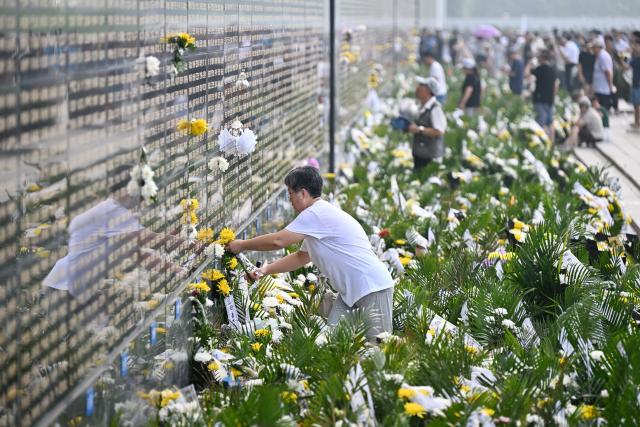 (260728) -- TANGSHAN, July 28, 2026 (Xinhua) -- A citizen places flowers near the name of her relative on a memorial wall inscribed with names of the victims at the Tangshan Earthquake Memorial Park in Tangshan, north China's Hebei Province, July 28, 2026. This year marks the 50th anniversary of the Tangshan Earthquake, a magnitude-7.8 quake that struck the city on July 28, 1976, taking the lives of more than 240,000 people and destroying virtually all buildings in the city.
   Crowds of people visited the Tangshan Earthquake Memorial Park on Tuesday to mourn and remember the victims in the devastating disaster. (Xinhua/Mu Yu)