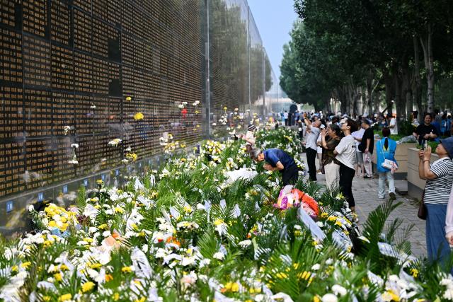 (260728) -- TANGSHAN, July 28, 2026 (Xinhua) -- People mourn in front of a memorial wall inscribed with names of the victims at the Tangshan Earthquake Memorial Park in Tangshan, north China's Hebei Province, July 28, 2026. This year marks the 50th anniversary of the Tangshan Earthquake, a magnitude-7.8 quake that struck the city on July 28, 1976, taking the lives of more than 240,000 people and destroying virtually all buildings in the city.
   Crowds of people visited the Tangshan Earthquake Memorial Park on Tuesday to mourn and remember the victims in the devastating disaster. (Xinhua/Mu Yu)