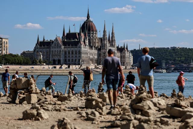 (260728) -- BUDAPEST, July 28, 2026 (Xinhua) -- People explore the exposed riverbed of the Danube River in Budapest, Hungary, July 28, 2026. The water level of the Danube River in Budapest fell to a record low of 31 centimeters on Tuesday, according to Hungary's General Directorate of Water Management. The reading surpassed the previous record low of 33 centimeters which was measured on October 25, 2018, as prolonged drought and a lack of rainfall continue to affect much of the region. (Photo by David Balogh/Xinhua)