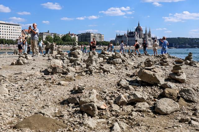 (260728) -- BUDAPEST, July 28, 2026 (Xinhua) -- People explore the exposed riverbed of the Danube River in Budapest, Hungary, July 28, 2026. The water level of the Danube River in Budapest fell to a record low of 31 centimeters on Tuesday, according to Hungary's General Directorate of Water Management. The reading surpassed the previous record low of 33 centimeters which was measured on October 25, 2018, as prolonged drought and a lack of rainfall continue to affect much of the region. (Photo by David Balogh/Xinhua)