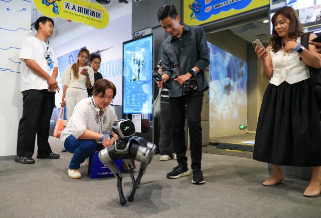 (260729) -- SHENZHEN, July 29, 2026 (Xinhua) -- Journalists and social media influencers from ASEAN countries interact with a robotic dog at a robotics zone in Shenzhen, south China's Guangdong Province, July 29, 2026. Over 20 journalists and social media influencers from ASEAN countries visited Shenzhen on Wednesday.
   This year marks the fifth anniversary of the establishment of the China-ASEAN Comprehensive Strategic Partnership. (Xinhua/Mao Siqian)