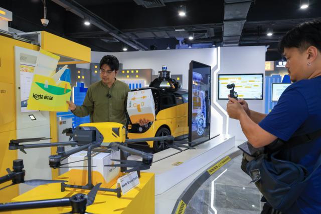 (260729) -- SHENZHEN, July 29, 2026 (Xinhua) -- A content creator (L) from Thailand explains drone delivery on camera at a big data center of the food delivery giant Meituan in Shenzhen, south China's Guangdong Province, July 29, 2026. Over 20 journalists and social media influencers from ASEAN countries visited Shenzhen on Wednesday.
   This year marks the fifth anniversary of the establishment of the China-ASEAN Comprehensive Strategic Partnership. (Xinhua/Mao Siqian)