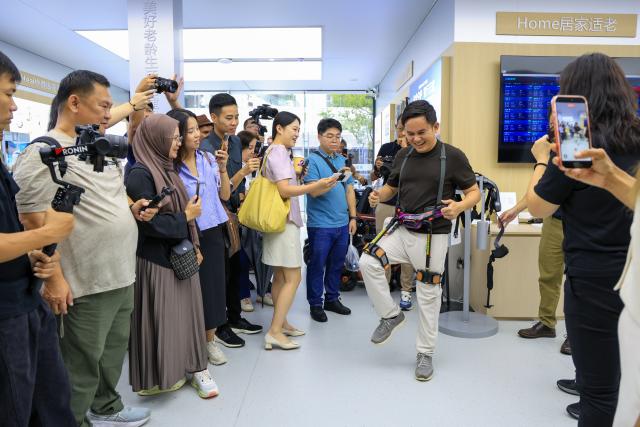 (260729) -- SHENZHEN, July 29, 2026 (Xinhua) -- A content creator from Myanmar tries an exoskeleton robot at a robotics zone in Shenzhen, south China's Guangdong Province, July 29, 2026. Over 20 journalists and social media influencers from ASEAN countries visited Shenzhen on Wednesday.
   This year marks the fifth anniversary of the establishment of the China-ASEAN Comprehensive Strategic Partnership. (Xinhua/Mao Siqian)