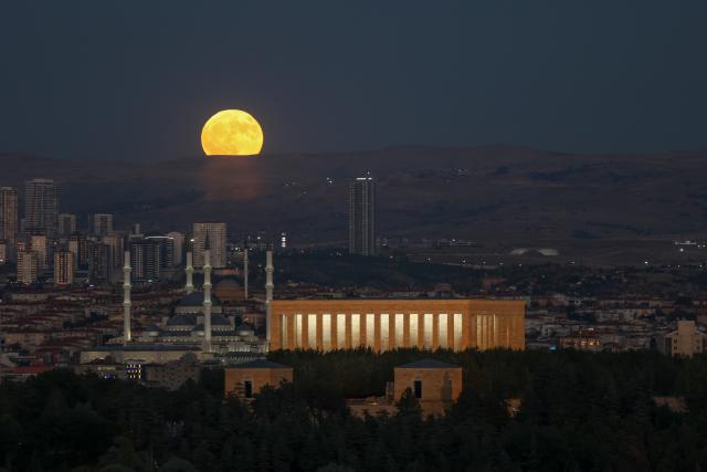 (260729) -- ANKARA, July 29, 2026 (Xinhua) -- A full moon rises behind Anitkabir, the mausoleum of Turkish Republic's founder Mustafa Kemal Ataturk and Kocatepe Mosque in Ankara, Türkiye, on July 29, 2026. (Mustafa Kaya/Handout via Xinhua)