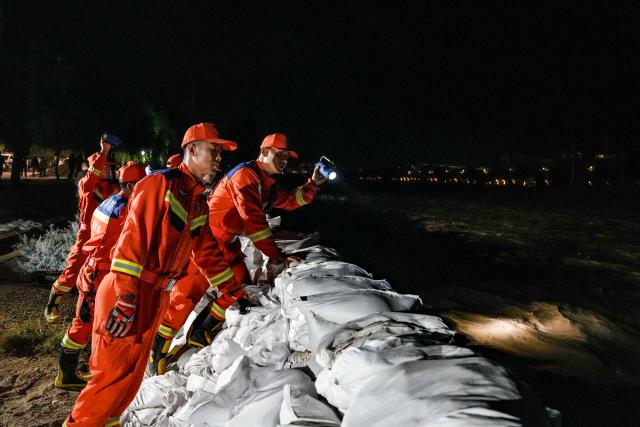 (260730) -- DUNHUANG, July 30, 2026 (Xinhua) -- Rescuers monitor water conditions along the Danghe River in Dunhuang, northwest China's Gansu Province, July 29, 2026. The water level of the Danghe River, which runs through Dunhuang City in northwest China's Gansu Province, rose rapidly following days of heavy rainfall and increased inflows from upstream. Local personnel in Dunhuang quickly mobilized for flood control and relief operations. (Xinhua/Lang Bingbing)