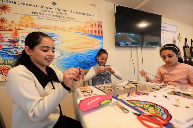 (260730) -- JERASH, July 30, 2026 (Xinhua) -- Children take part in a hands-on activity at a Chinese intangible cultural heritage exhibition during the 40th Jerash Festival of Culture and Arts in Jerash, Jordan, July 29, 2026. China's traditional music and intangible cultural heritage took center stage on Wednesday at the 40th Jerash Festival of Culture and Arts, one of the Middle East's largest cultural events.
  The performance featured traditional Chinese instruments, including the erhu, bamboo flute, suona and pipa, alongside intangible cultural heritage elements such as nose-flute performance and leaf-blowing music.
  An accompanying exhibition in the festival's international cultural area showcased Hainan's intangible cultural heritage, including coconut-shell carving, grass weaving, collage art and traditional stone-rubbing techniques. (Photo by Mohammad Abu Ghosh/Xinhua)
