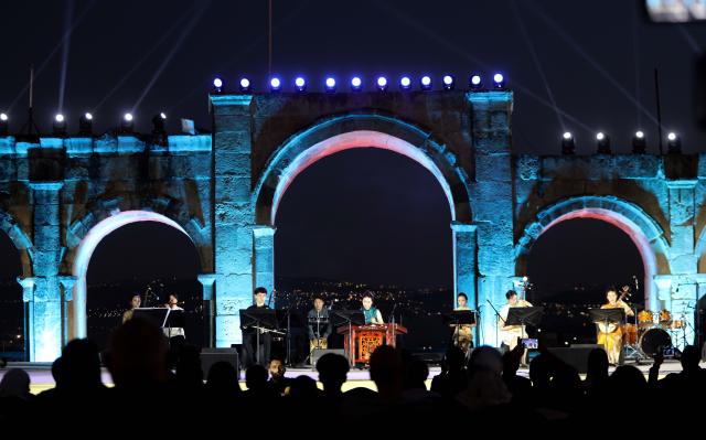 (260730) -- JERASH, July 30, 2026 (Xinhua) -- Chinese artists perform during the 40th Jerash Festival of Culture and Arts at the ancient Roman Hippodrome in Jerash, Jordan, July 29, 2026. China's traditional music and intangible cultural heritage took center stage on Wednesday at the 40th Jerash Festival of Culture and Arts, one of the Middle East's largest cultural events.
  The performance featured traditional Chinese instruments, including the erhu, bamboo flute, suona and pipa, alongside intangible cultural heritage elements such as nose-flute performance and leaf-blowing music.
  An accompanying exhibition in the festival's international cultural area showcased Hainan's intangible cultural heritage, including coconut-shell carving, grass weaving, collage art and traditional stone-rubbing techniques. (Photo by Mohammad Abu Ghosh/Xinhua)