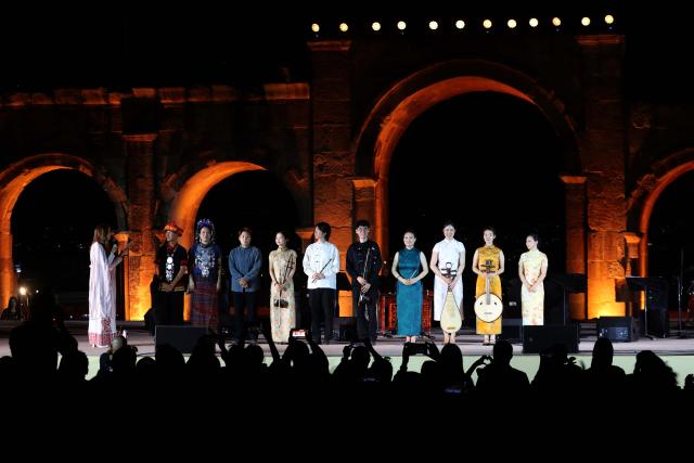 (260730) -- JERASH, July 30, 2026 (Xinhua) -- Chinese artists take a bow after their performance during the 40th Jerash Festival of Culture and Arts at the ancient Roman Hippodrome in Jerash, Jordan, July 29, 2026. China's traditional music and intangible cultural heritage took center stage on Wednesday at the 40th Jerash Festival of Culture and Arts, one of the Middle East's largest cultural events.
  The performance featured traditional Chinese instruments, including the erhu, bamboo flute, suona and pipa, alongside intangible cultural heritage elements such as nose-flute performance and leaf-blowing music.
  An accompanying exhibition in the festival's international cultural area showcased Hainan's intangible cultural heritage, including coconut-shell carving, grass weaving, collage art and traditional stone-rubbing techniques. (Photo by Mohammad Abu Ghosh/Xinhua)