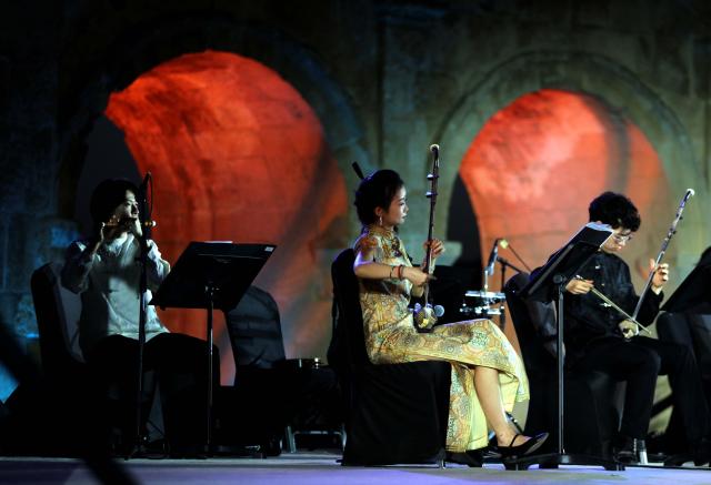 (260730) -- JERASH, July 30, 2026 (Xinhua) -- Chinese artists perform during the 40th Jerash Festival of Culture and Arts at the ancient Roman Hippodrome in Jerash, Jordan, July 29, 2026. China's traditional music and intangible cultural heritage took center stage on Wednesday at the 40th Jerash Festival of Culture and Arts, one of the Middle East's largest cultural events.
  The performance featured traditional Chinese instruments, including the erhu, bamboo flute, suona and pipa, alongside intangible cultural heritage elements such as nose-flute performance and leaf-blowing music.
  An accompanying exhibition in the festival's international cultural area showcased Hainan's intangible cultural heritage, including coconut-shell carving, grass weaving, collage art and traditional stone-rubbing techniques. (Photo by Mohammad Abu Ghosh/Xinhua)