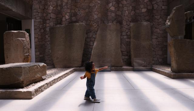 (260730) -- OAXACA, July 30, 2026 (Xinhua) -- A child walks past stone carvings depicting human figures at the Monte Alban Site Museum in Oaxaca, Mexico, on July 29, 2026. Built around 500 B.C., Monte Alban is located in the southern Mexican state of Oaxaca. It was inscribed on the UNESCO World Heritage List in 1987. (Xinhua/Liu Wenhui)