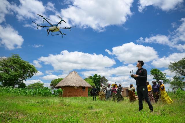 (260730) -- DAR ES SALAAM, July 30, 2026 (Xinhua) -- Ma Dengrong (front R), a member of the 4th batch of Chinese agricultural experts in Zimbabwe, operates an agricultural drone to demonstrate pesticide spraying to local residents at the China-aided agricultural demonstration village in Zindi, Shamva District of Mashonaland Central Province, Zimbabwe, Jan. 26, 2026. TO GO WITH XINHUA HEADLINES ON JULY 30, 2026. (Xinhua/Yang Guang)