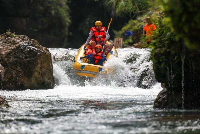 (260730) -- HUANGPING, July 30, 2026 (Xinhua) -- Tourists enjoy rafting at a scenic area in Huangping County, southwest China's Guizhou Province, July 29, 2026. During the summer vacation, Huangping has leveraged its mountain springs and canyon landscapes to develop a rafting tourism brand, attracting visitors for a refreshing getaway while boosting local tourism and incomes. (Xinhua/Yang Wenbin)