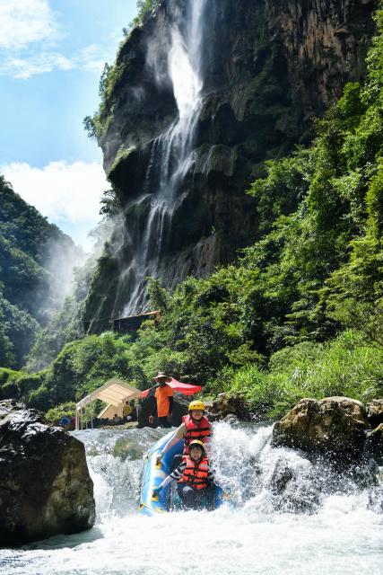 (260730) -- HUANGPING, July 30, 2026 (Xinhua) -- Tourists enjoy rafting at a scenic area in Huangping County, southwest China's Guizhou Province, July 29, 2026. During the summer vacation, Huangping has leveraged its mountain springs and canyon landscapes to develop a rafting tourism brand, attracting visitors for a refreshing getaway while boosting local tourism and incomes. (Xinhua/Yang Wenbin)