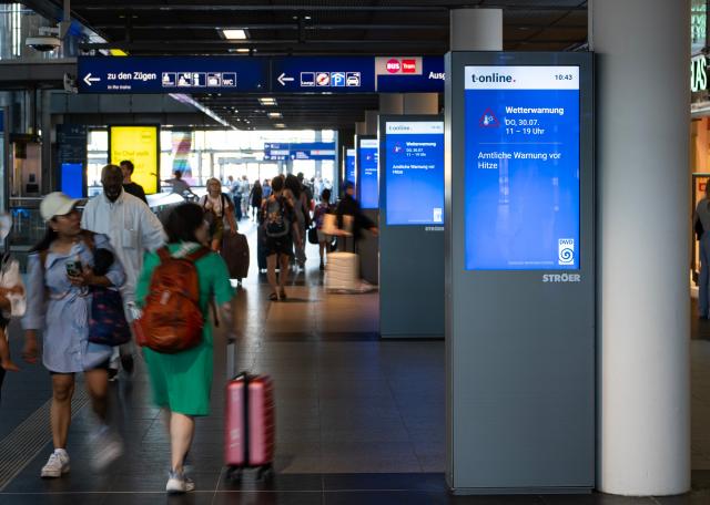 (260730) -- BERLIN, July 30, 2026 (Xinhua) -- Passengers walk past heat warning display in the main train station in Berlin, capital of Germany, July 30, 2026. Germany recorded an estimated 9,800 heat-related deaths as of July 19, surpassing the annual total for every year since 2016, the Robert Koch Institute (RKI), the country's leading public health authority, said Thursday. (Xinhua/Zhang Haofu)