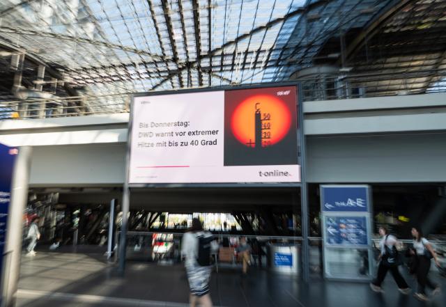 (260730) -- BERLIN, July 30, 2026 (Xinhua) -- Passengers walk past heat warning display in the main train station in Berlin, capital of Germany, July 30, 2026. Germany recorded an estimated 9,800 heat-related deaths as of July 19, surpassing the annual total for every year since 2016, the Robert Koch Institute (RKI), the country's leading public health authority, said Thursday. (Xinhua/Zhang Haofu)