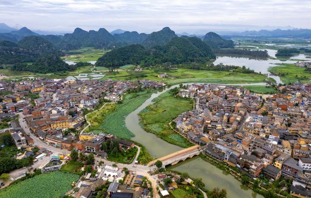 (260731) -- WENSHAN, July 31, 2026 (Xinhua) -- A drone photo taken on July 31, 2026 shows a view of the Puzhehei Village within the Puzhehei scenic area in Qiubei County, Wenshan Zhuang and Miao Autonomous Prefecture, southwest China's Yunnan Province. The Puzhehei scenic area has seen an increased number of tourists during the country's summer peak tourism season. (Xinhua/Chen Xinbo)