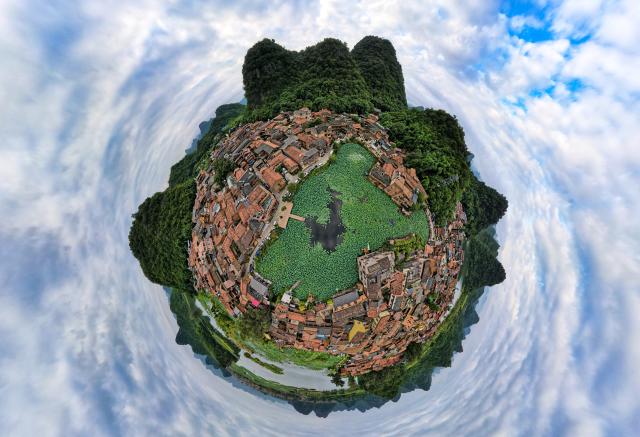 (260731) -- WENSHAN, July 31, 2026 (Xinhua) -- A panoramic drone photo taken on July 31, 2026 shows a view of the Xianrendong Village within the Puzhehei scenic area in Qiubei County, Wenshan Zhuang and Miao Autonomous Prefecture, southwest China's Yunnan Province. The Puzhehei scenic area has seen an increased number of tourists during the country's summer peak tourism season. (Xinhua/Chen Xinbo)