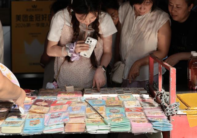 (260731) -- SHENYANG, July 31, 2026 (Xinhua) -- Tourists select souvenirs at the Xita neighborhood in Shenyang, northeast China's Liaoning Province, July 23, 2026. Xita is a distinctive neighborhood in Shenyang which is known for its wide variety of local specialties and attracts visitors from across the country. (Xinhua/Li Gang)