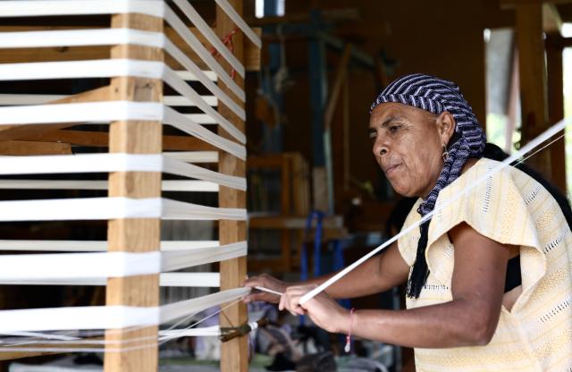 (260731) -- OAXACA, July 31, 2026 (Xinhua) -- Artisan Amalia Hernandez arranges warp threads at her family's textile workshop in San Pablo Villa de Mitla, Oaxaca State, Mexico, July 28, 2026. The southern Mexican state of Oaxaca is known for its handwoven textiles and embroidered garments. Local artisans make clothing, rugs and other items using weaving, dyeing and embroidery techniques. Sold at markets and handicraft fairs, these colorful creations remain part of everyday life in Oaxaca. (Xinhua/Liu Wenhui)