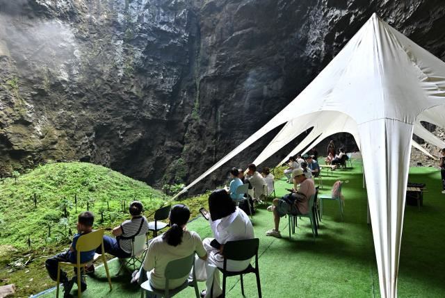 (260731) -- XUAN'EN, July 31, 2026 (Xinhua) -- Tourists have fun at a scenic spot in Xuan'en County in Enshi Tujia and Miao Autonomous Prefecture, central China's Hubei Province, July 29, 2026. Since the summer vacation began, tourist attractions in Xuan'en have seen a surge in visitors. (Photo by Song Wen/Xinhua)