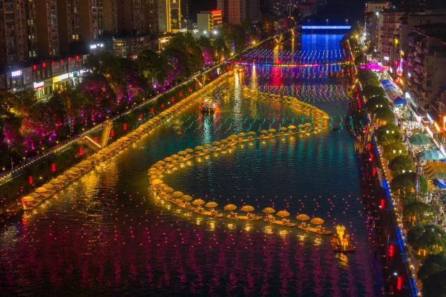 (260731) -- XUAN'EN, July 31, 2026 (Xinhua) -- An aerial drone photo taken on July 29, 2026 shows tourists rafting and enjoying the night view on Gongshui River in Xuan'en County in Enshi Tujia and Miao Autonomous Prefecture, central China's Hubei Province. Since the summer vacation began, tourist attractions in Xuan'en have seen a surge in visitors. (Xinhua/Du Zixuan)
