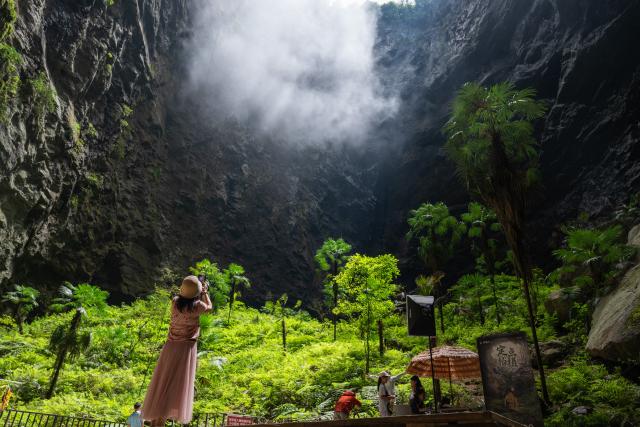 (260731) -- XUAN'EN, July 31, 2026 (Xinhua) -- Tourists have fun at a scenic spot in Xuan'en County in Enshi Tujia and Miao Autonomous Prefecture, central China's Hubei Province, July 29, 2026. Since the summer vacation began, tourist attractions in Xuan'en have seen a surge in visitors. (Xinhua/Du Zixuan)
