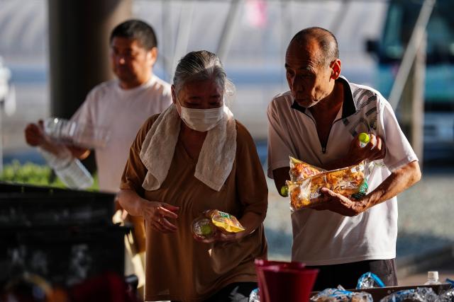 (260731) -- KUMAMOTO, July 31, 2026 (Xinhua) -- People receive relief materials at a shelter in Kumamoto Prefecture, Japan, July 30, 2026. The death toll from a powerful earthquake that struck Japan's Kumamoto Prefecture has risen to 35, the prefectural government said Friday. (Xinhua/Jia Haocheng)